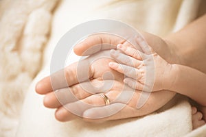 Newborn child hand. Closeup of baby hand into parents hands. Family, maternity and birth concept.