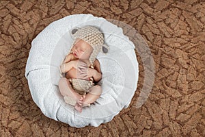 The newborn child sleeping on a white blanket