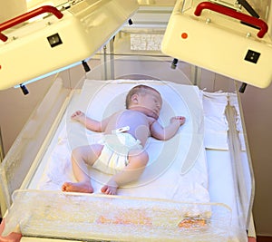 Newborn child under ultraviolet lamps