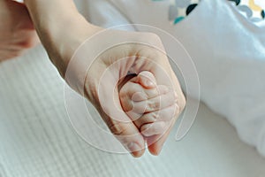 Newborn children`s hand in mother hand. Mom and her Child. Happy Family concept