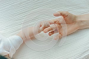 Newborn children`s hand in mother hand. Mom and her Child. Happy Family concept