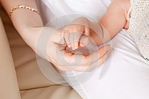 Newborn children`s hand in mother hand. Mom and her Child. Happy Family concept. Beautiful conceptual image of Maternity