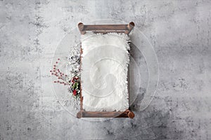 Newborn Christmas backdrop - wooden bed with white faux fur, snow covered branches with red berries on white background