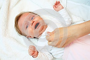 Newborn cries when he is dressed