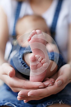 Parts of the body. The legs of the child in the hands of the mother.