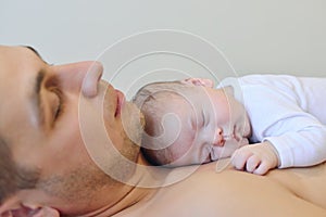 A newborn girl falls asleep on her father