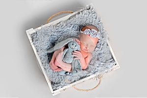 Newborn girl hugging toy while sleeping