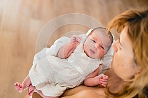 Newborn girl in loving arms of her mother