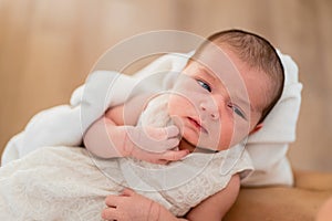 Newborn girl in loving arms of her mother