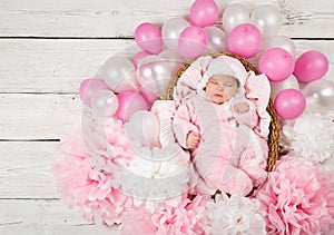 Newborn Girl sleeping in Pink Fluffy Bodysuit. Baby Birth Celebration with Balloons and Paper Flower Decoration. Cute Little Child
