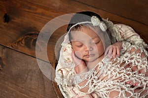 Newborn Girl Sleeping in Wooden Bowl