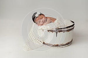 Newborn Girl Sleeping in Wooden Bucket