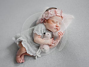 Newborn Girl Sleeps In Gray Dress With Flamingo Toy