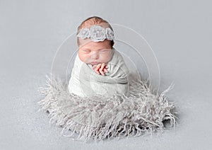 Newborn girl wrapped in blue wrap