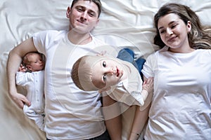 Newborn Identical twins on the bed, on a white background. Life style, emotions of kids. Infant Babies