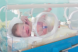 Newborn in incubator