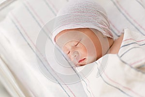 Newborn infant baby boy lying in a hospital bed