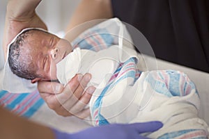 Newborn infant baby getting his first bath in the hospital