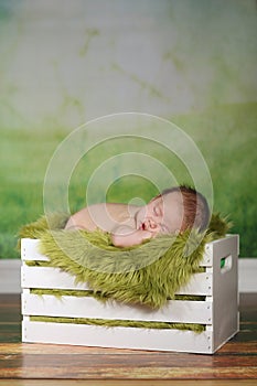 Newborn Infant Boy Sleeping on a Cute Set