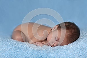 Newborn Infant Boy Sleeping on a Cute Set