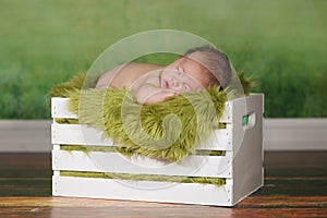 Newborn Infant Boy Sleeping on a Cute Set