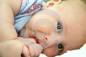 Newborn Infant Girl Laying Down Sucking Her Thumb