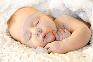 Newborn Infant Girl Sleeping Peacefully in White Blankets