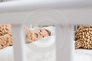 Newborn infant lay in wooden home crib