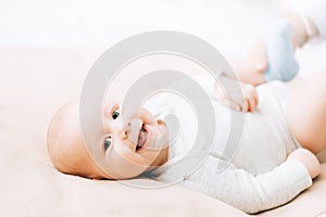 Newborn laughing baby lying on the bed. Caring for newborn children