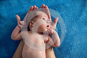 Newborn lies on two arms of his father