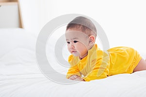 Newborn little baby prone on the bed at home