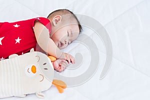 Newborn little baby sleeping on white bed at home