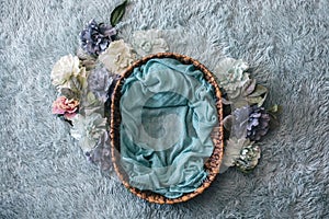 Newborn photography background - woven basket with teal faux fur and blue and pink peonies