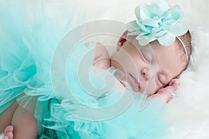 Newborn portrait of baby girl in teal tutu sleeping.