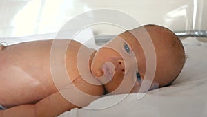 A newborn preterm baby in a plastic crib lies close up