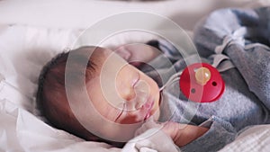 newborn with rubber nipple baby sleeping. happy family a maternity hospital hospital kid dream concept. newborn close-up