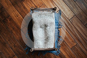 Newborn rustic background - wooden bed with grey blanket, blue throw on dark wooden backdrop