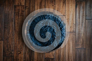 Newborn rustic background - wooden bowl with blue faux fur on dark wooden backdrop