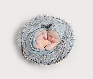 Newborn sleeping curled in his wrap, topview photo