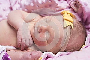 Newborn sleeping naked on her side.