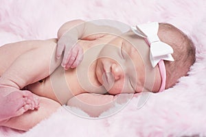 Newborn sleeping naked on her side.