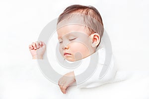 Newborn sleeping on the white bed isolated on white background