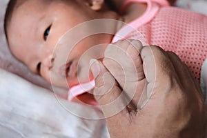 Newborn tiny baby hands and father