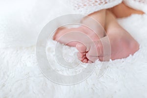 Newborn toddler feet on a white background. Selective focus