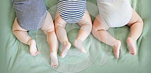 Newborn triplets lie on a stomach