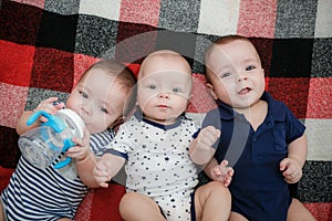 Newborn triplets are lying in the bed