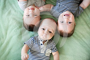 Newborn triplets are lying in the bed