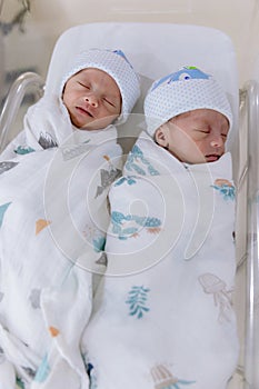 Newborn twins sleeping. Newborn Babies Twins Sleep in Bed. Lovely sleep of the newborns babies on the bed.