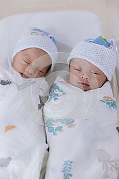 Newborn twins sleeping. Newborn Babies Twins Sleep in Bed. Lovely sleep of the newborns babies on the bed.