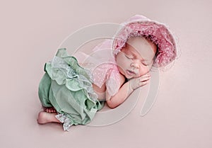 Newborn wearing lace cap and pantaloons